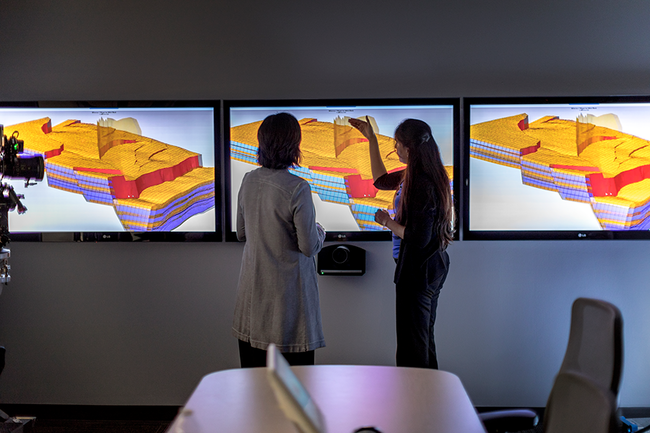 Photo of two reservoir engineers looking at modeling screens.