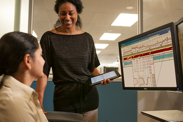 Photo of two Baker Hughes engineers collaborating at a computer screen.