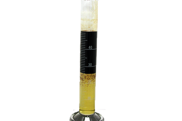 Photo of a beaker showing the separation of contaminated drilling fluid.