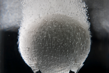 in - tallic压裂球在液体中崩解的照片。